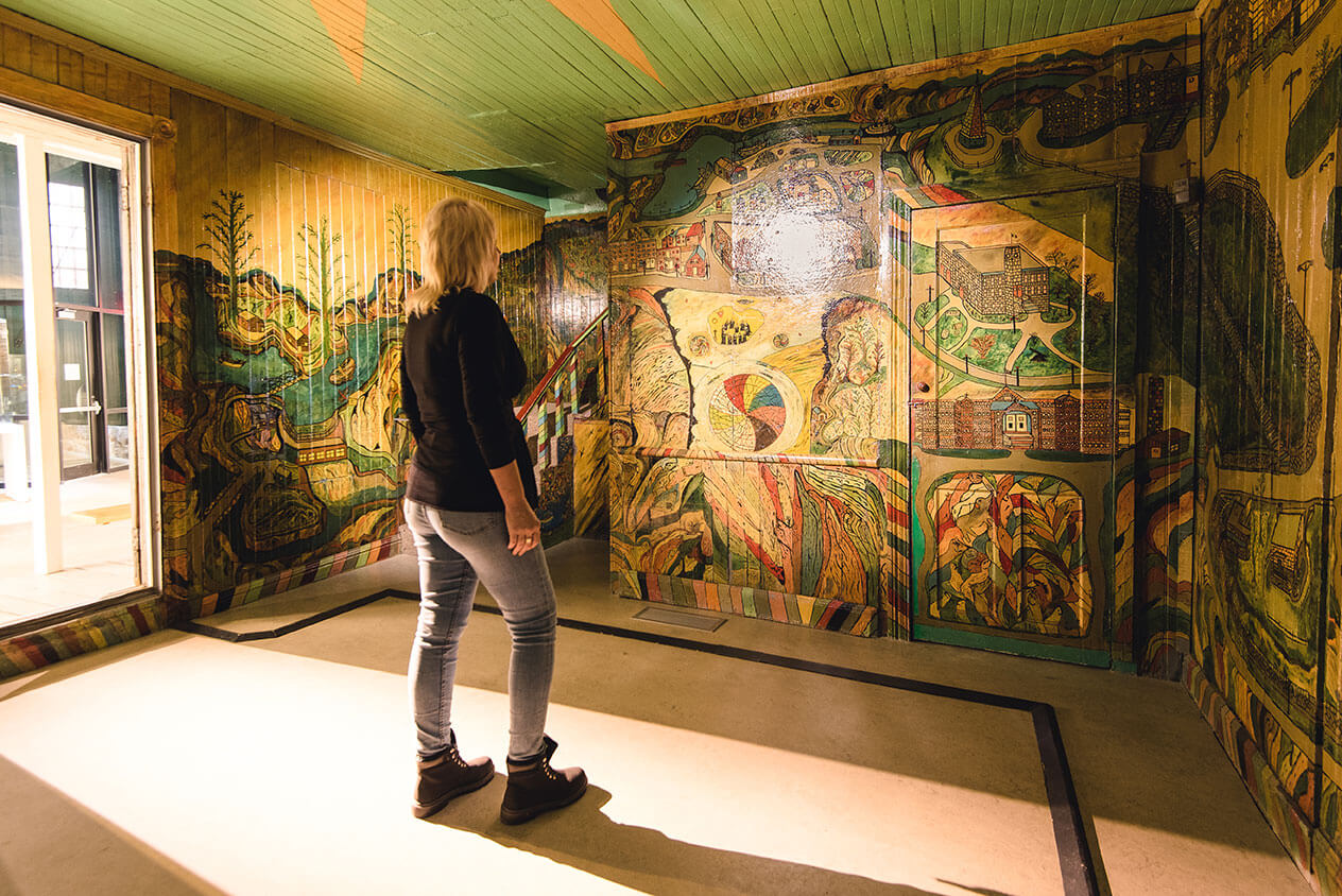 Femme devant une murale à la Pulperie de Chicoutimi.