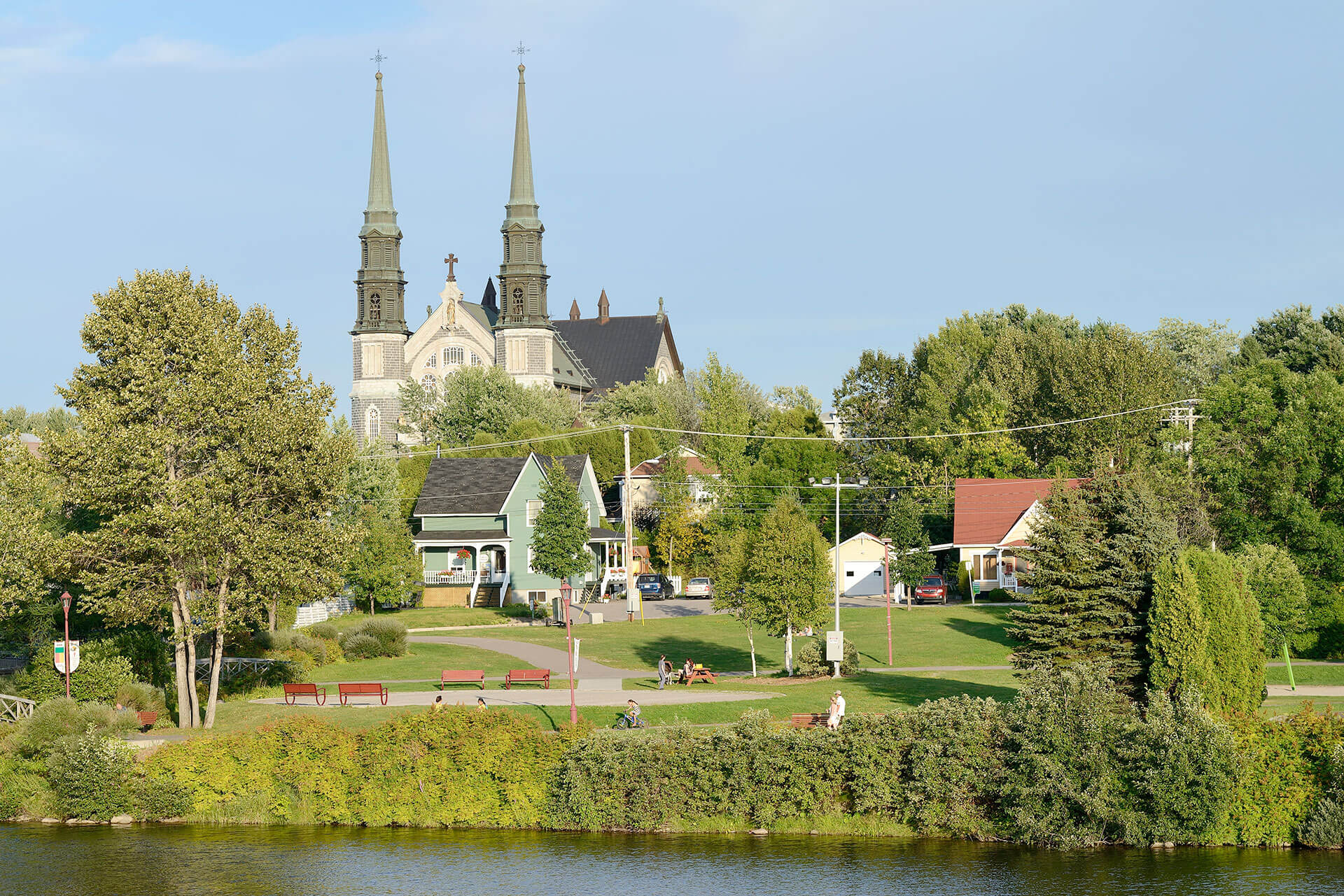 Clocher d'une église avec maisons au Centre Ville de Jonquière au Parc de la rivière aux Sables.
