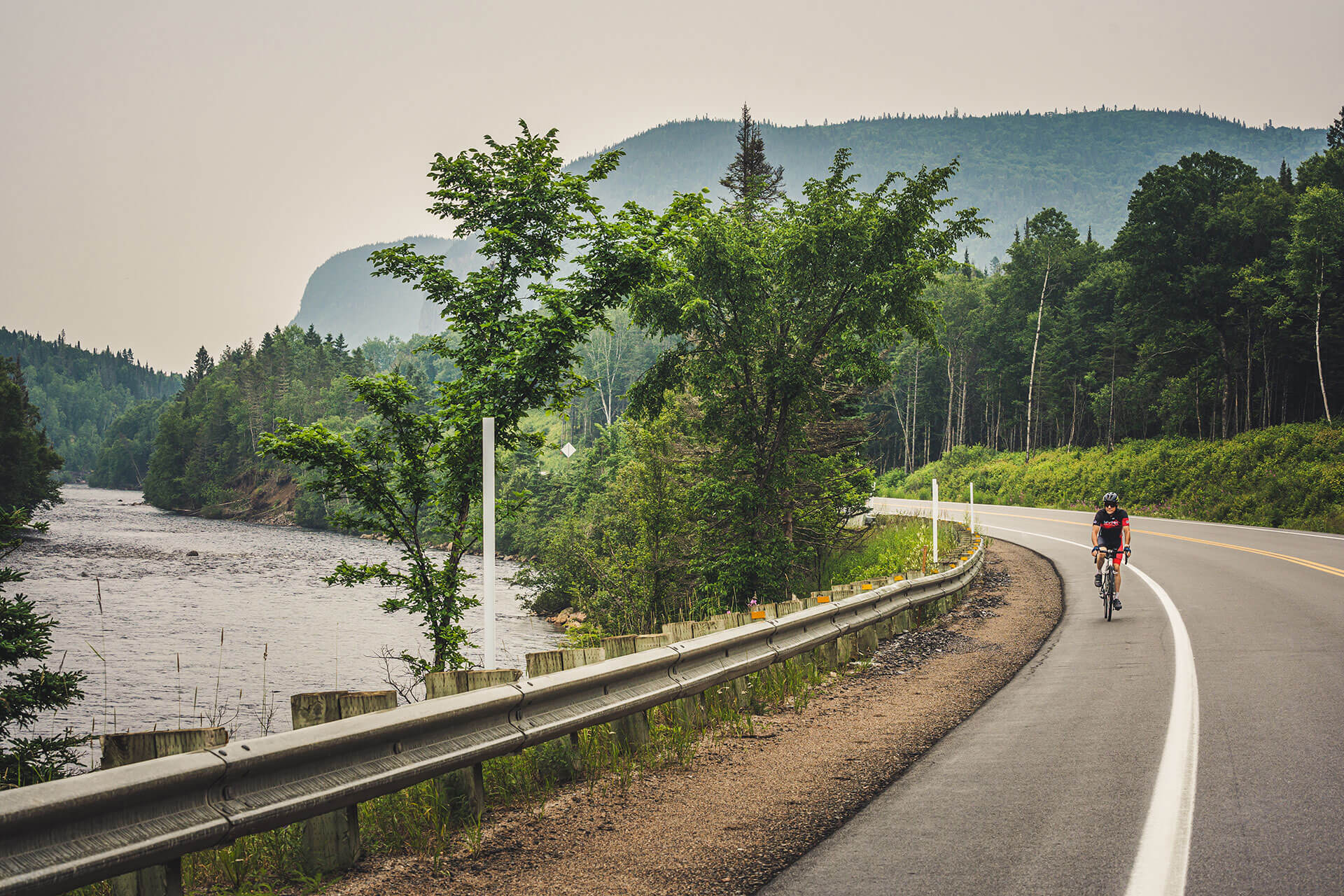 Cycliste roulant sur une route au Saguenay.